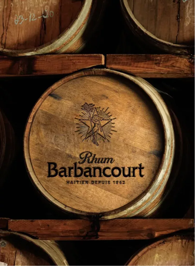 Fût en bois estampillé Rhum Barbancourt avec logo gravé et empilé dans un chai